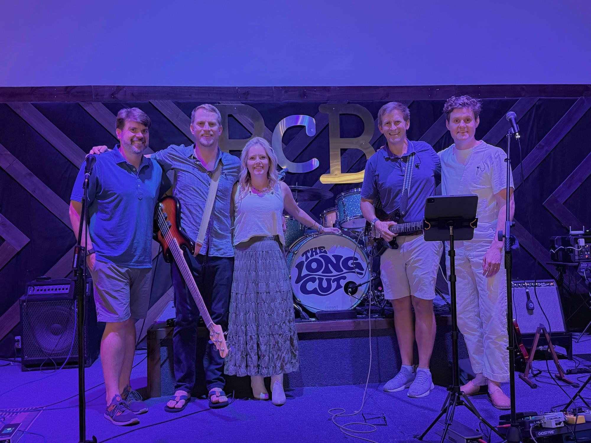 The Long Cut on stage at BC Brewery, under purple light, with the logo on the bass drum.